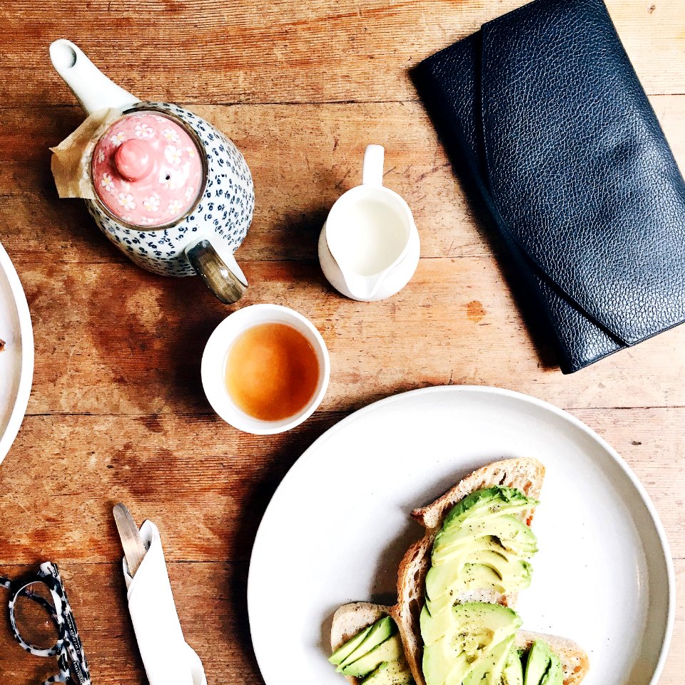 black leather long wallet beside plate