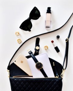 women's sunglasses and black bag with watch and iPhone 6 photo