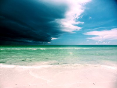 clear white sand beach under cloudy sky photo