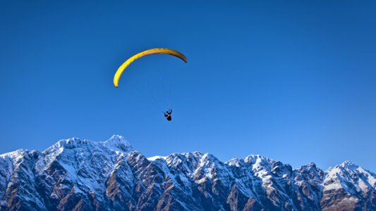 man on parachute near the mountain photo