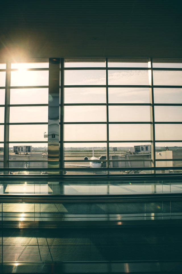 gray metal window and white plane outside during daytime