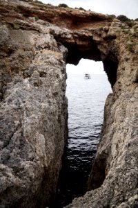 rock formation near sea with sailing ship