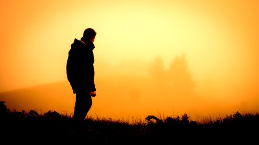 silhouette of man standing open field photo