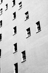 The exterior of a white building with randomly placed windows on each floor.