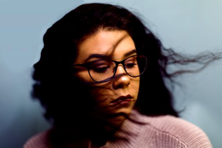 selective photography of woman wearing gray knit top and black framed eyeglasses photo