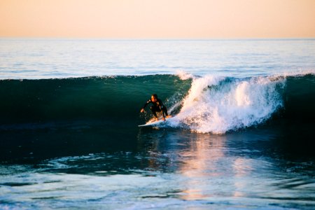 man surfing on ocean wave during daytime photo