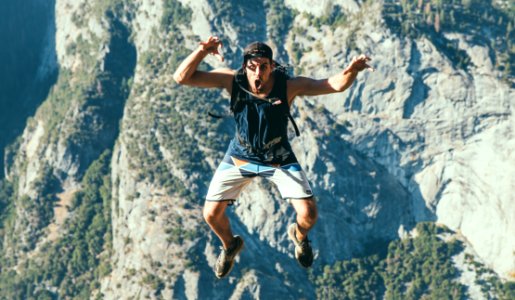 man jumping on top of the mountian photo