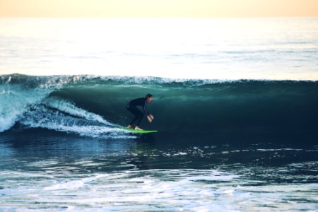 man surfing on sea at daytime photo