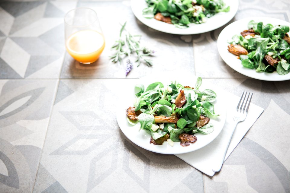 three salad dishes beside clear drinking glass cup