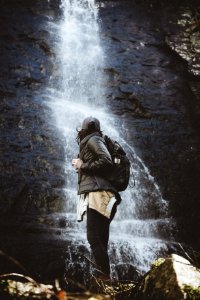 person standing beside waterfalls photo