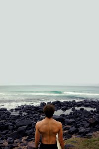 man holding surfboard near sea photo
