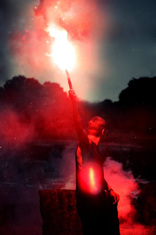 shallow focus photo of person holding flare