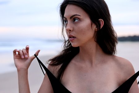 woman about to take off her clothes at the beach photo