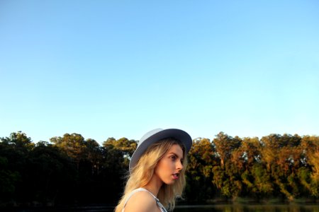 woman standing near body of water and trees