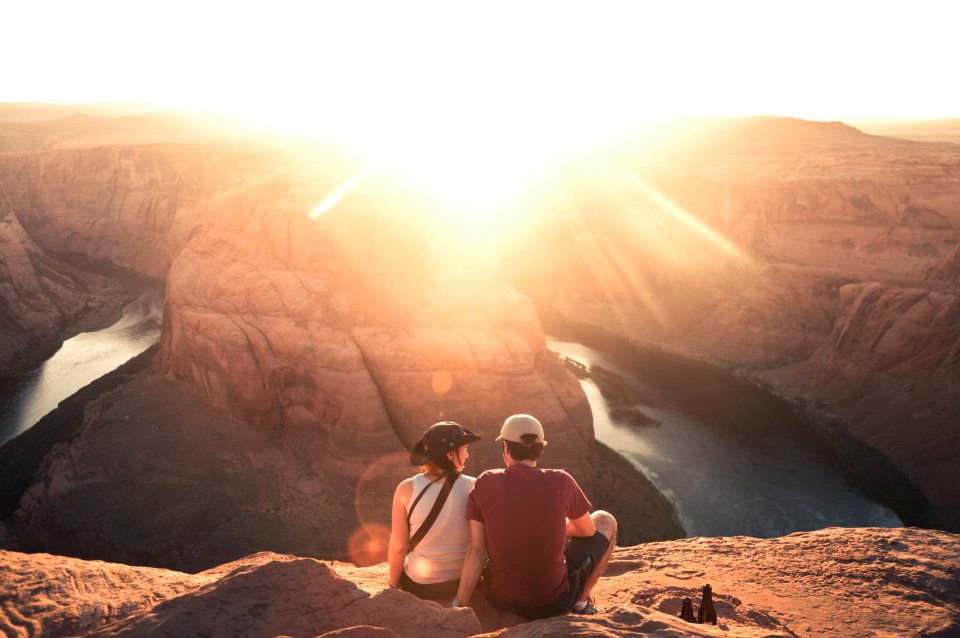 man and woman sitting on rock formation