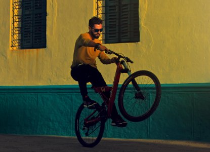 man riding bicycle doing tricks near building photography photo