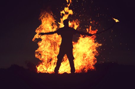 person standing in front of fire during night time photo