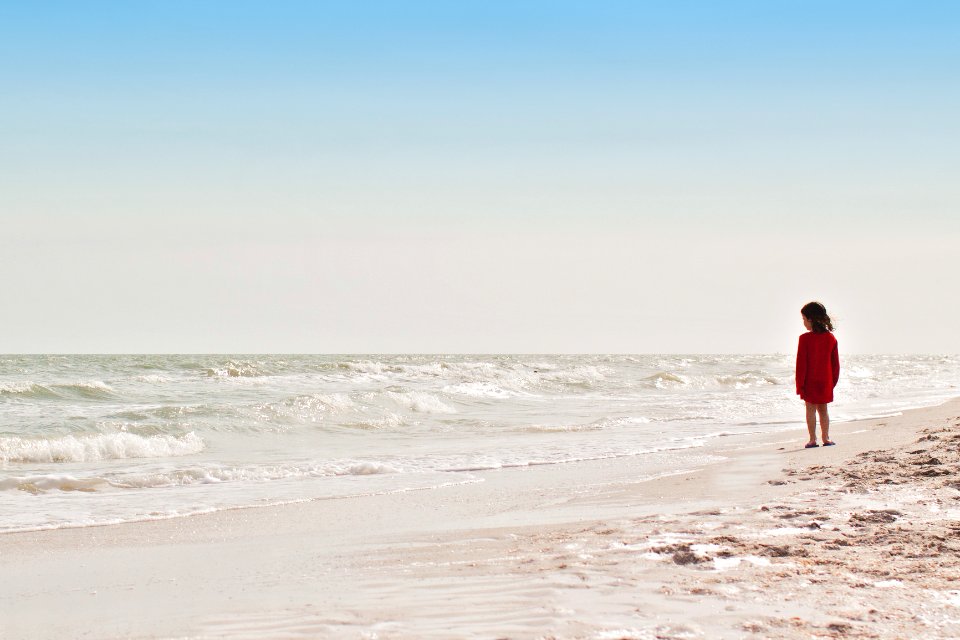 girl standing on seashore during daytime photo