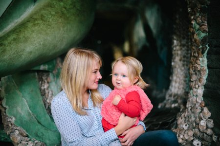 woman holding child while sitting down photo