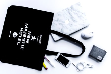 flat lay photography of tote bag beside iPhone and wallet
