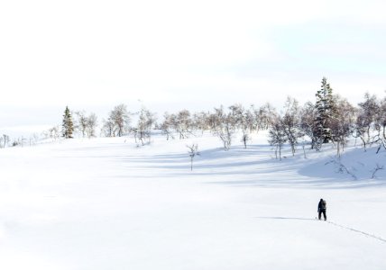 man walking on snow field during daytime photo