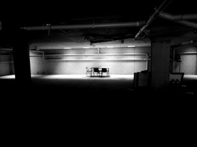 table with chairs near wall in a dark room photo