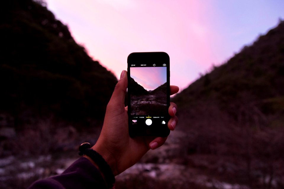 person holding iPhone displaying camera application