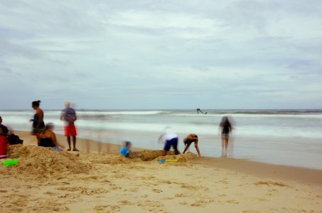 group of people standing on beach shore photo