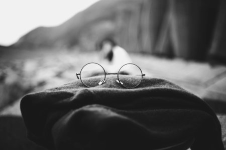 grayscale photo of hippie eyeglasses on cloth photo