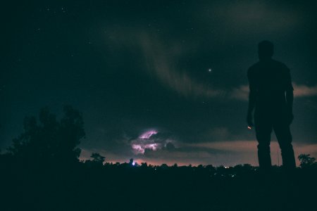 silhouette of man standing under night sky