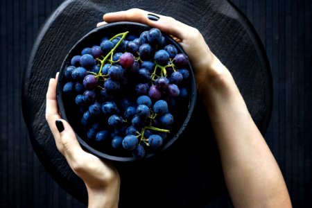 person holding bowl of grapes
