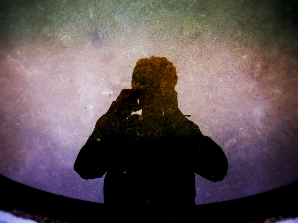 silhouette photography of man holding camera