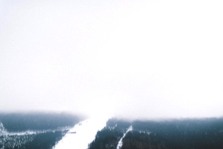 A high view of a snowy wooded slope shrouded in heavy mist in Špindlerův Mlýn photo