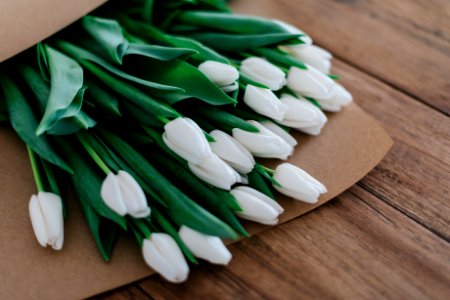 close-up photography of white petaled flower bouquet on brown wooden table