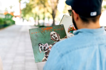 man holding vinyl album in shallow focus photography photo