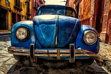 blue vehicle parked near building at daytime photo