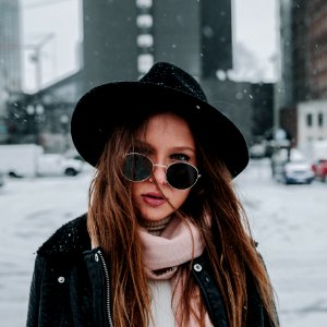 shallow focus photography of woman wearing hat while snowing