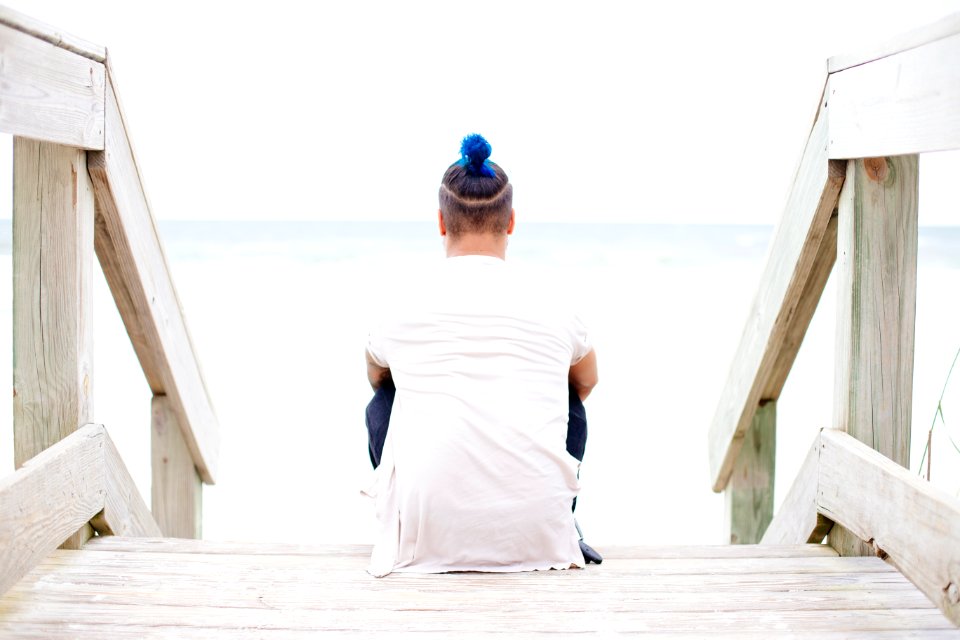 man sitting on wooden staircase