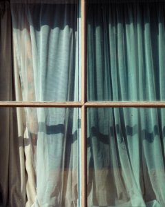 glass window with teal and white curtain photo