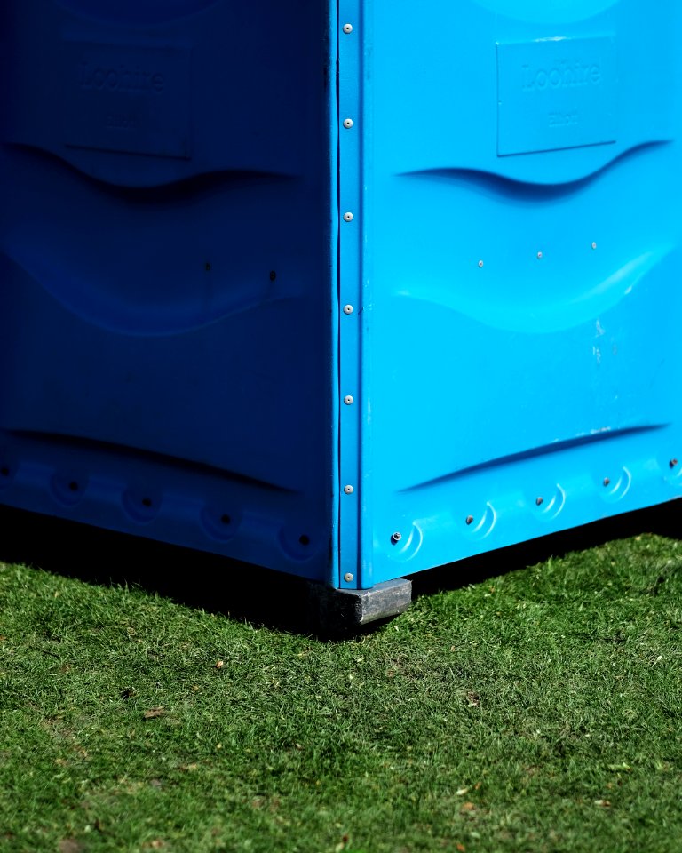 blue metal storage box on green grass
