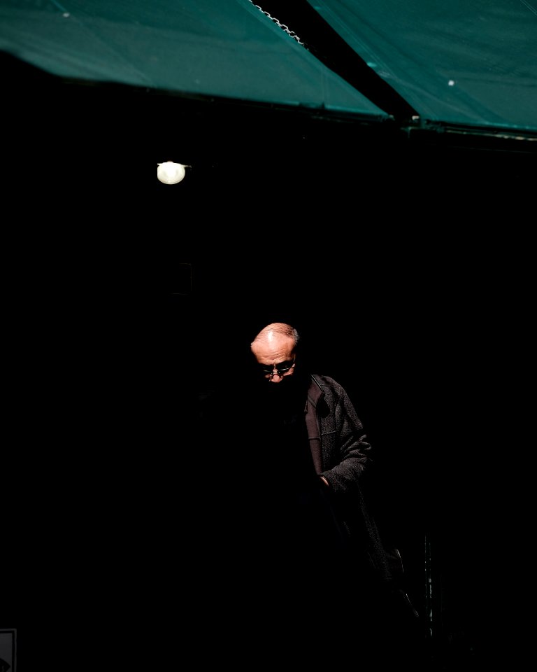 man wearing black jacket inside dark room