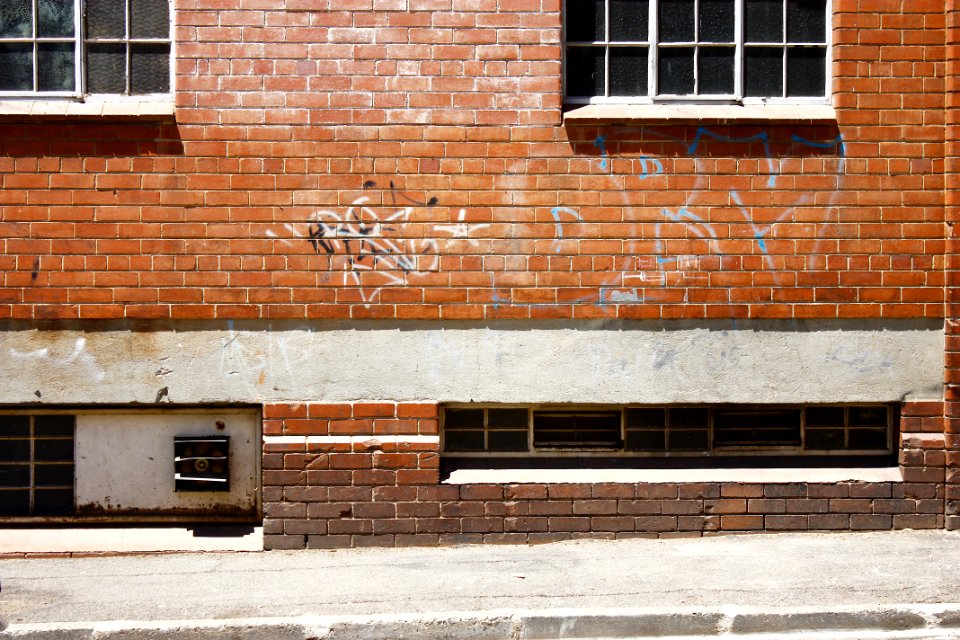 white spray paint texts printed on brown brick wall