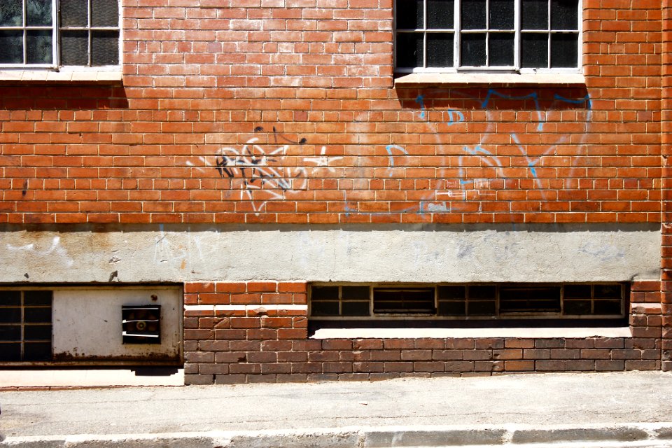 white spray paint texts printed on brown brick wall photo