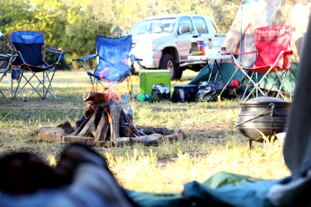 camping chairs in front of bonfire near pickup truck photo