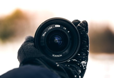 person holding Rokinon zoom lens