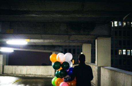 man holding balloon lot during night photo