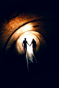 silhouette of man and woman inside tunnel photo