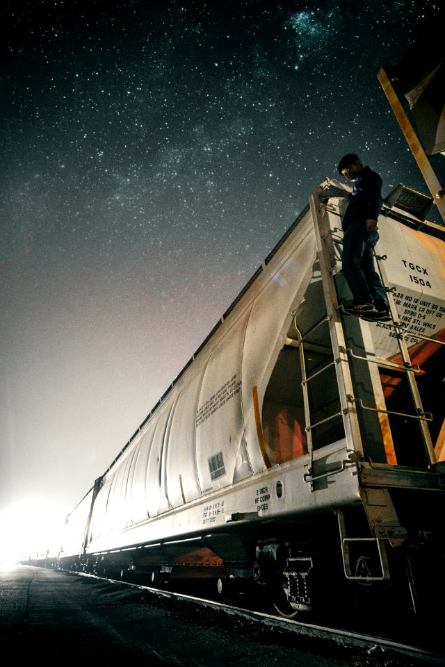 man riding white train on track at nighttime