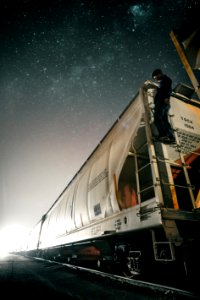 man riding white train on track at nighttime