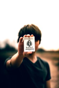 selective focus photography of person holding ace of spades card photo
